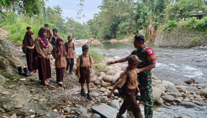 Jembatan Belum Terbangun, Babinsa Bantu Anak Sekolah Sebrangi Sungai dengan Rakit Bambu di Tapua
